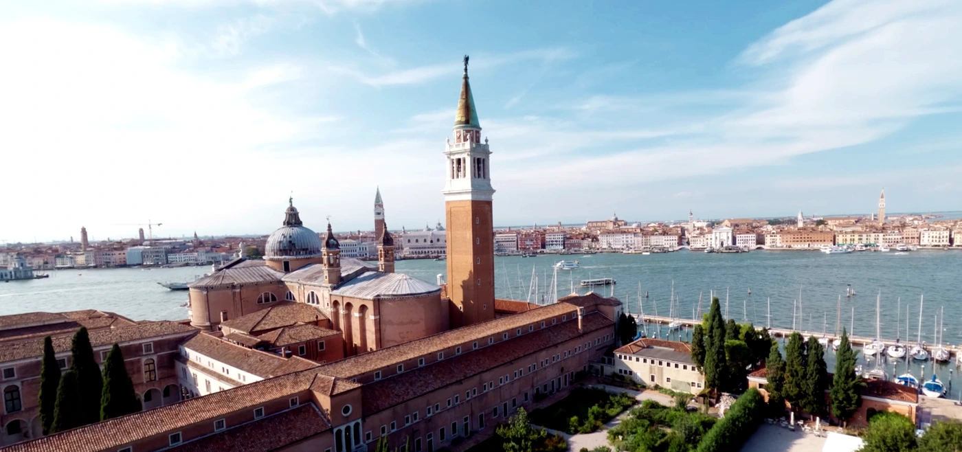 Vista aérea del campanario de San Giorgio Maggiore sobre el agua, al cerrar la visita a Homo Faber 2026